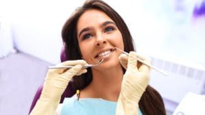 Woman smiling at doctor inspecting her teeth